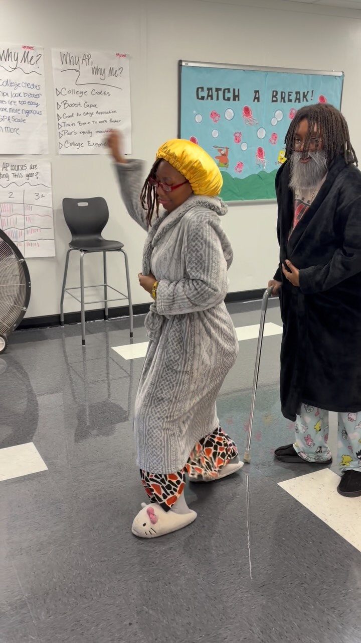 Two students dressed as senior citizens with a robe, cane, and fake beard.