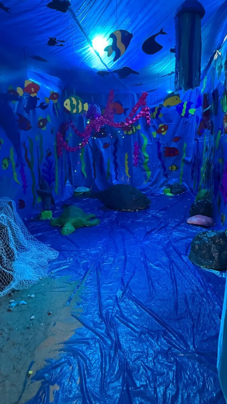 Underwater themed room decoration with blue plastic, fish cutouts, and sea turtles.
