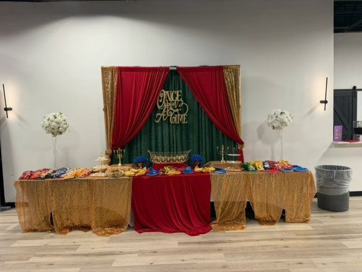 Fairytale themed dessert table with red and gold curtains and Once Upon A Time sign