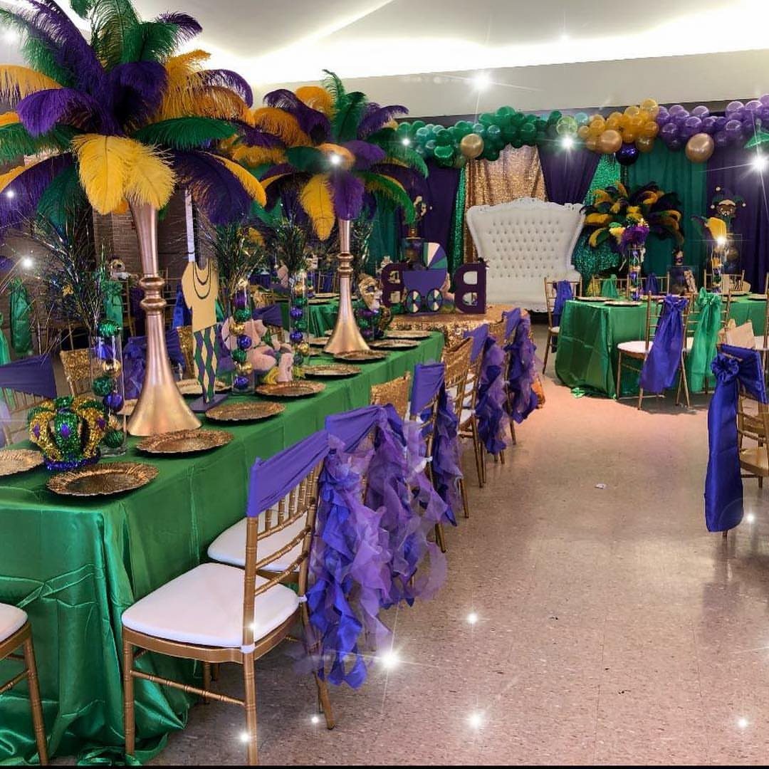 Banquet room with green tablecloths, purple chair sashes, and colorful feather centerpieces.