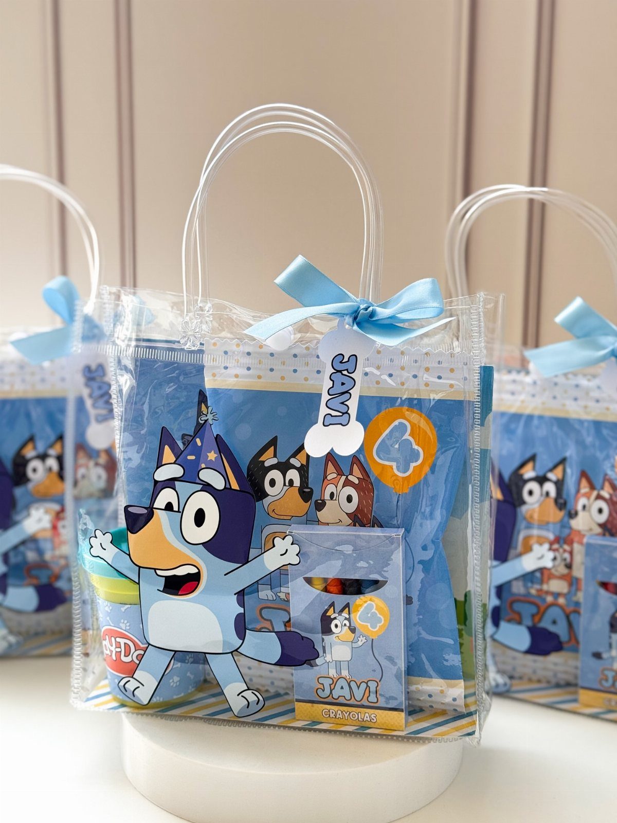 Bluey themed goodie bags with blue ribbons and crayons for a kids party