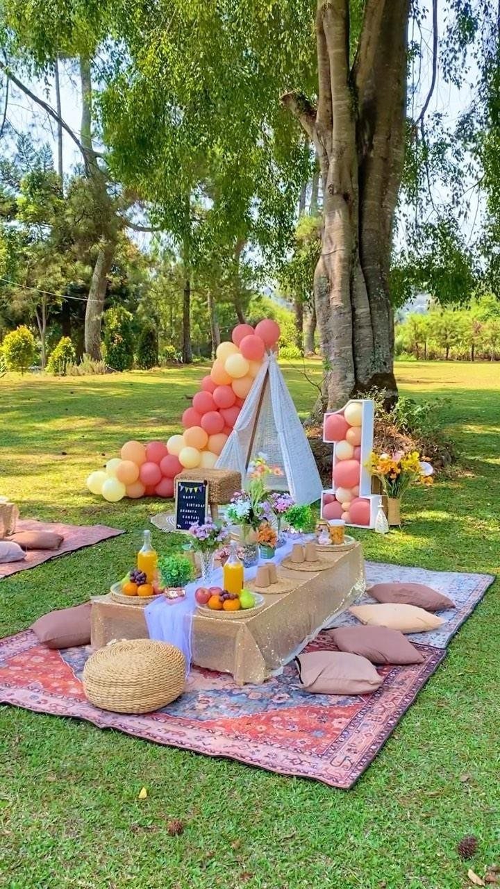 Low picnic table with cushions and teepee under a tree in a park