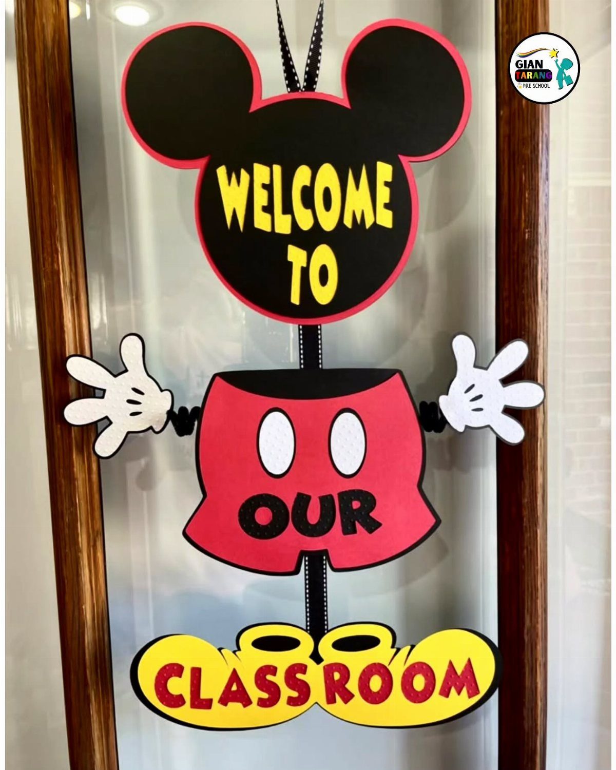 Mickey Mouse shaped welcome sign on a classroom door with bright yellow text.