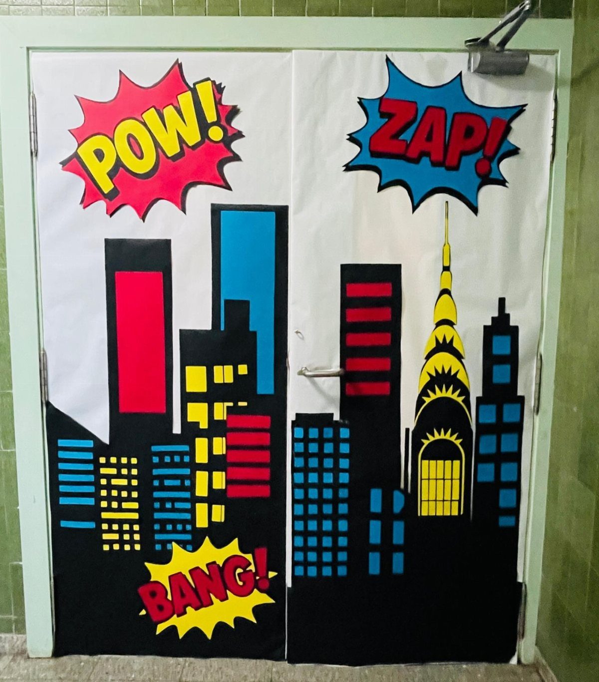 Comic book style city skyline on a door with POW, ZAP, and BANG bubbles.
