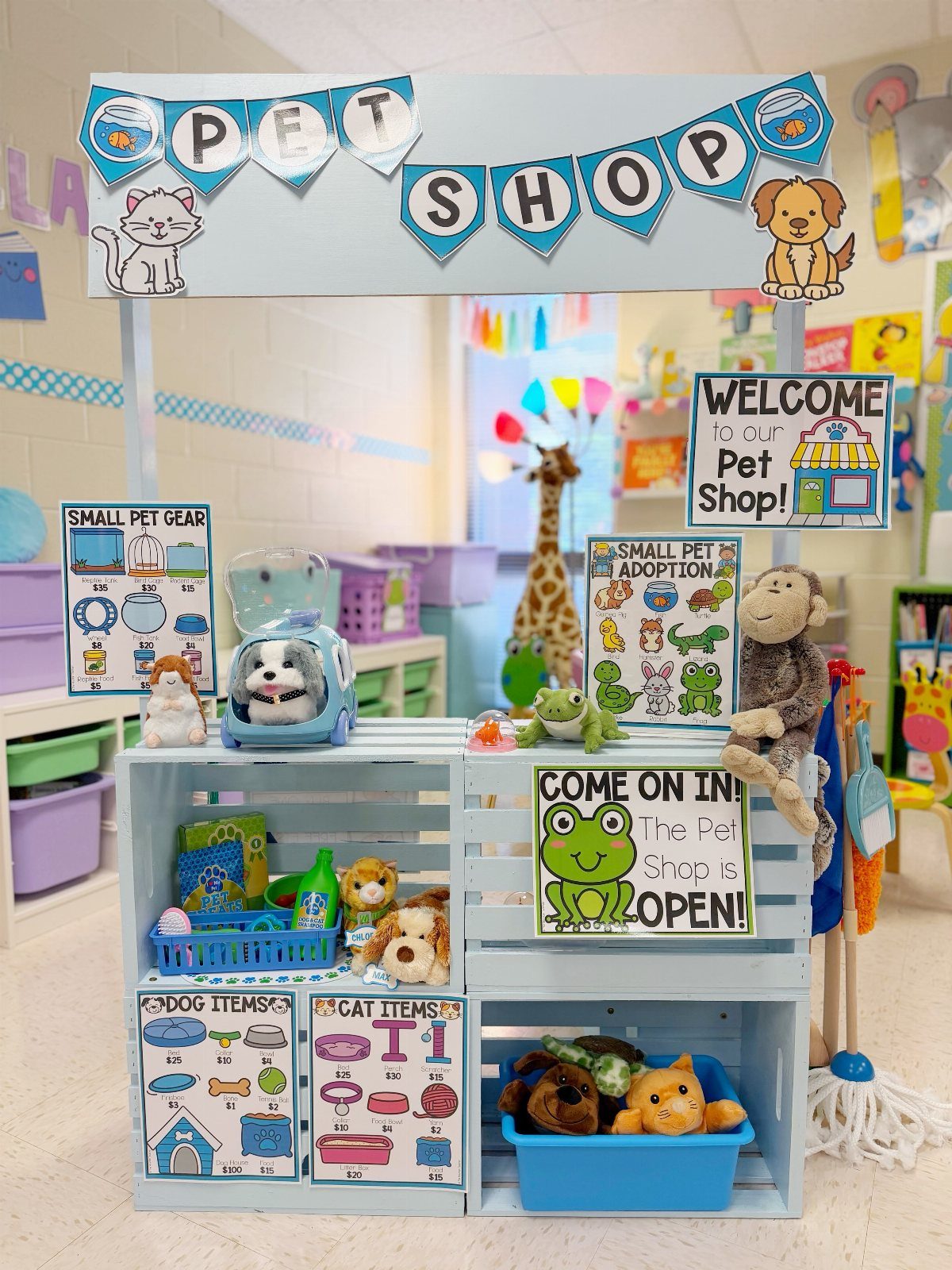 Pretend play pet shop setup in a kindergarten classroom with stuffed animals and signs.