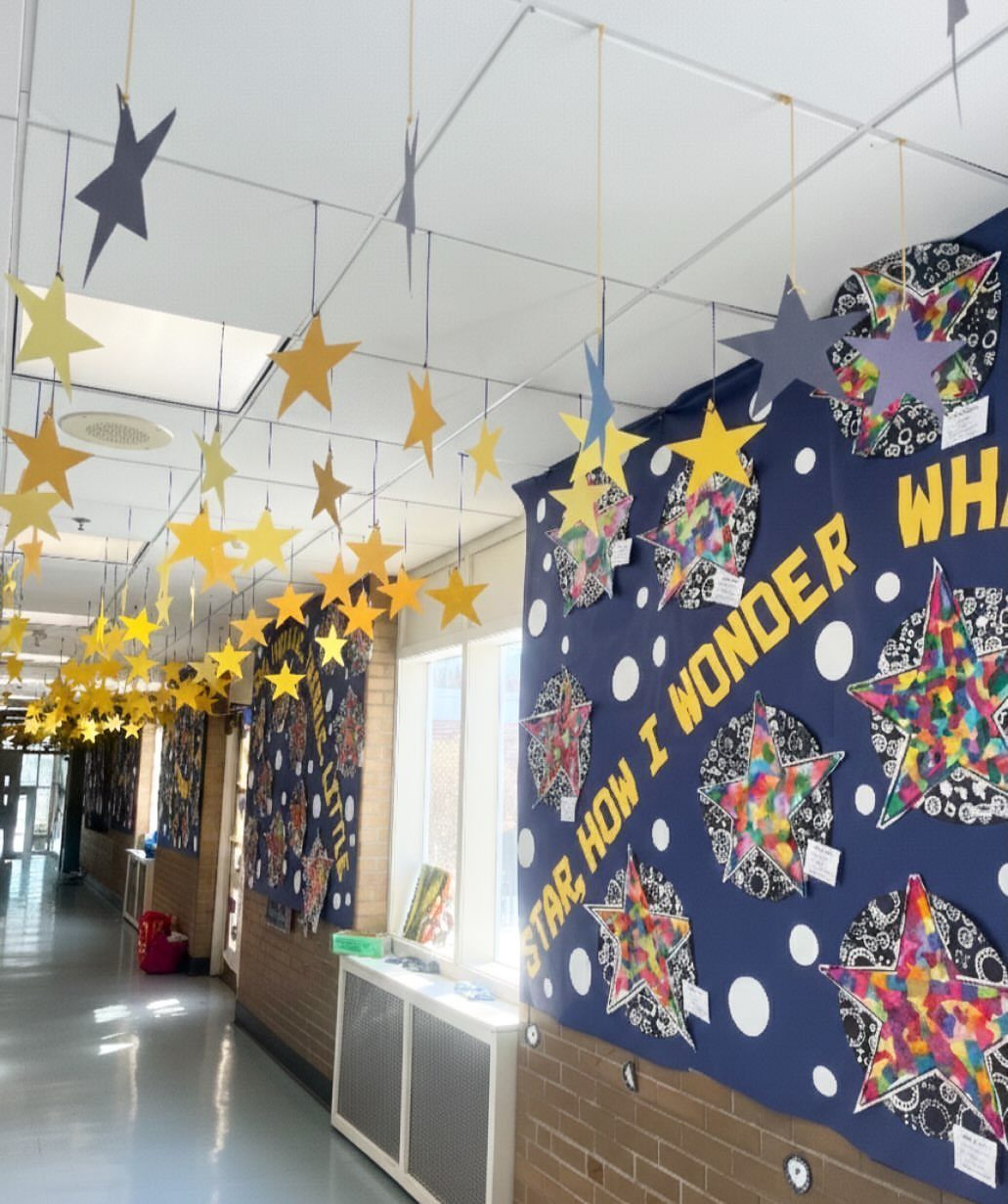 Star-themed classroom decorations with hanging yellow stars and a blue star bulletin board.