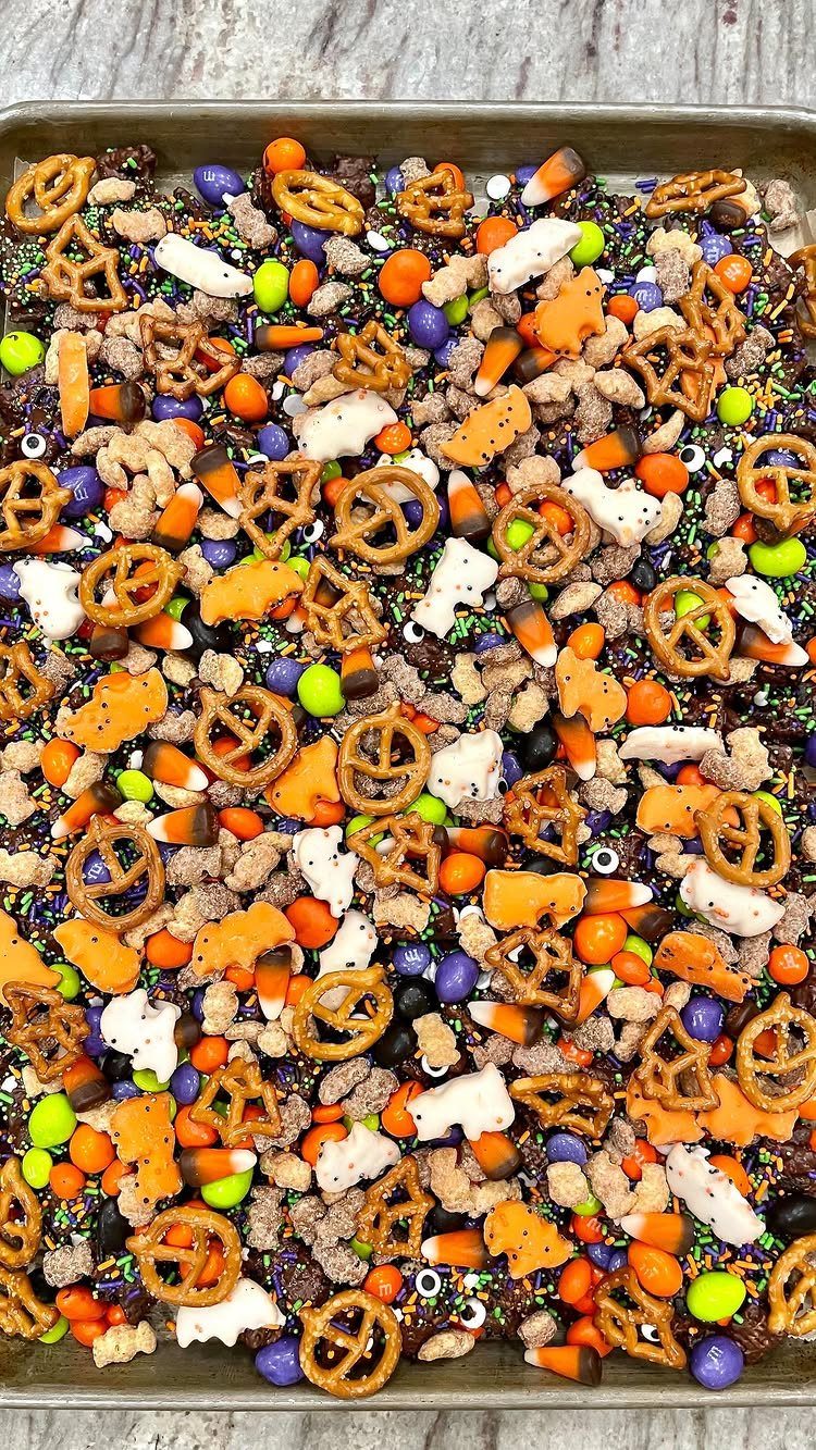 Halloween snack mix with pretzels and candy corn on a metal baking sheet