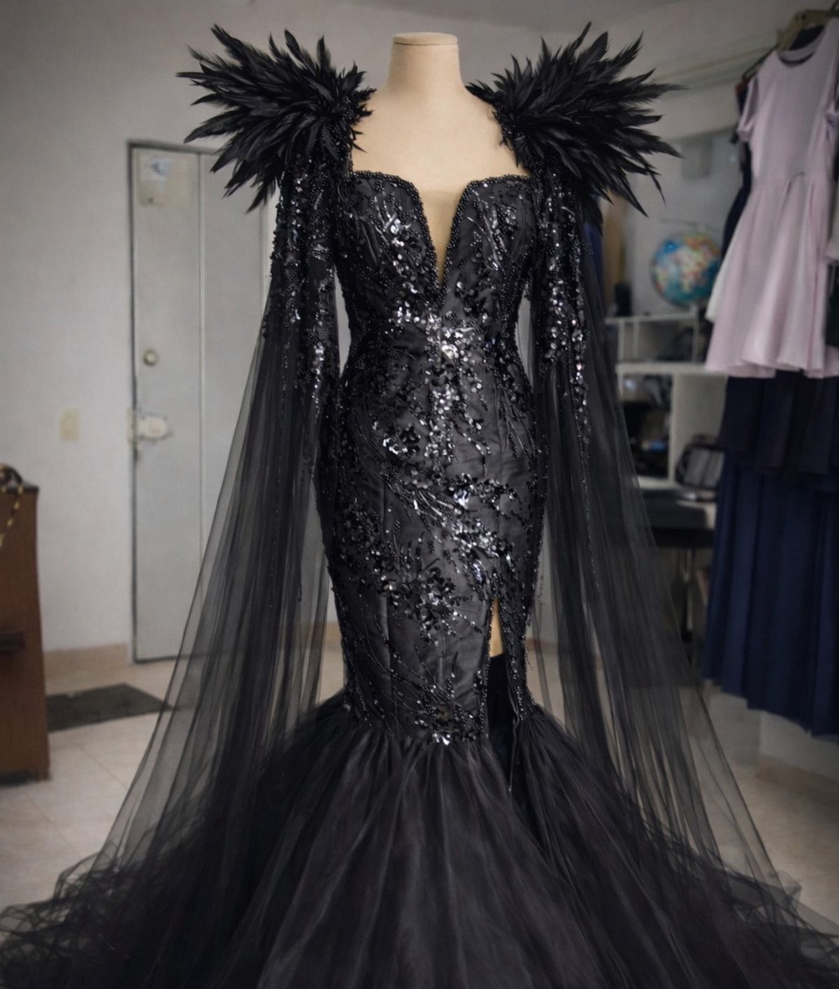 Black sequined mermaid gown with feathered shoulders and a voluminous tulle skirt.