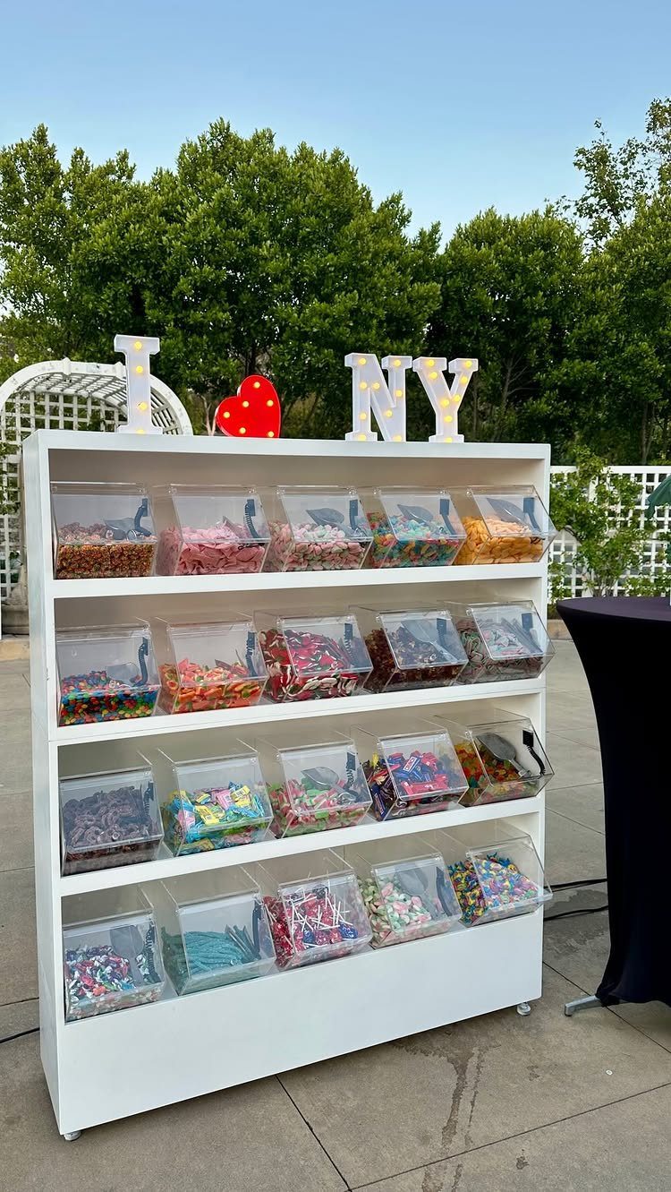 Candy buffet station with illuminated I LOVE NY marquee letters outdoors