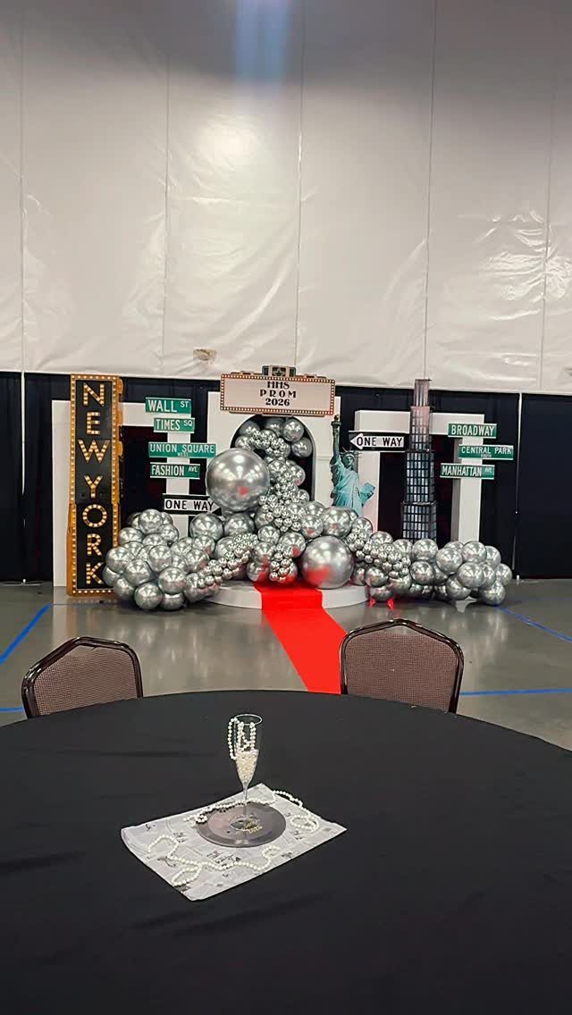 New York City themed prom decor with silver balloons and a red carpet.