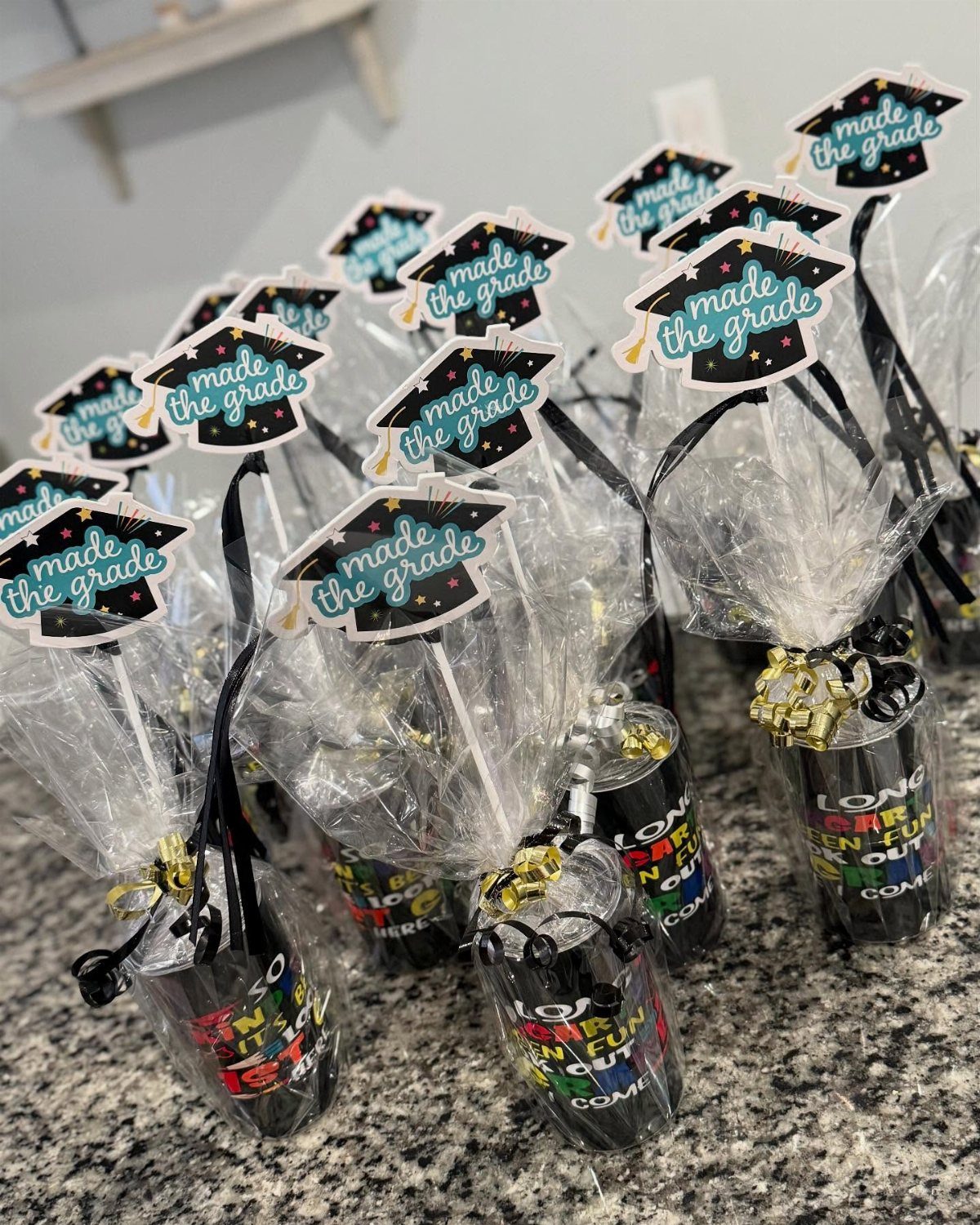 Graduation party favors in clear bags with graduation cap tags on a counter.