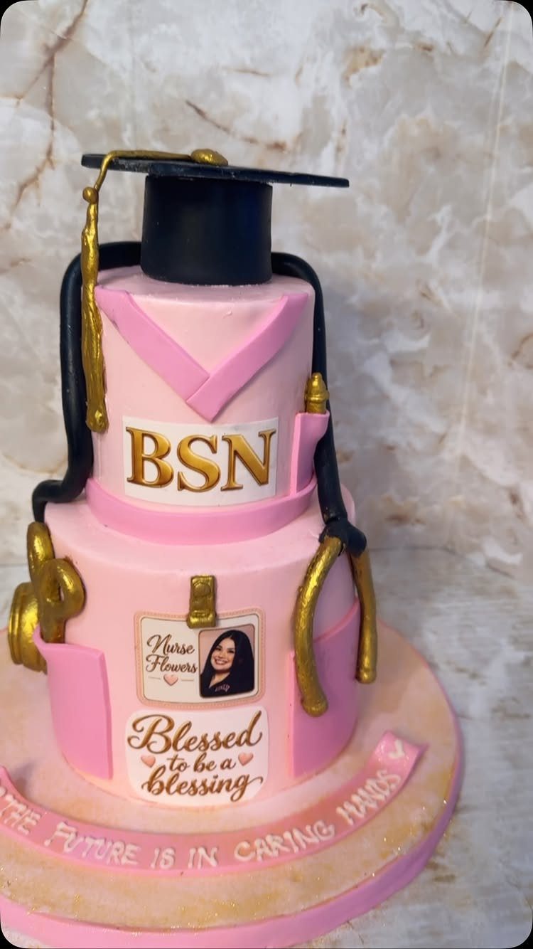 Pink nursing graduation cake with a black mortarboard, gold stethoscope, and BSN sign.