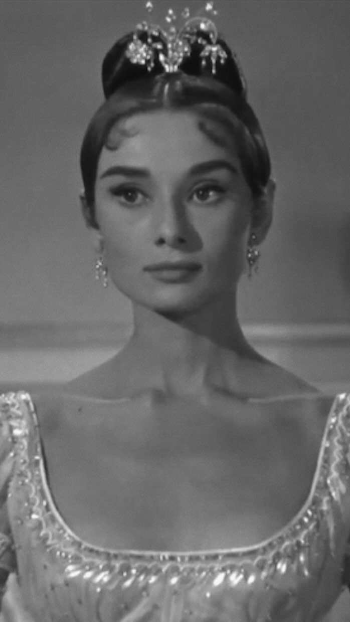 Woman in a sparkling sequined gown wearing a tiara and elegant jewelry.