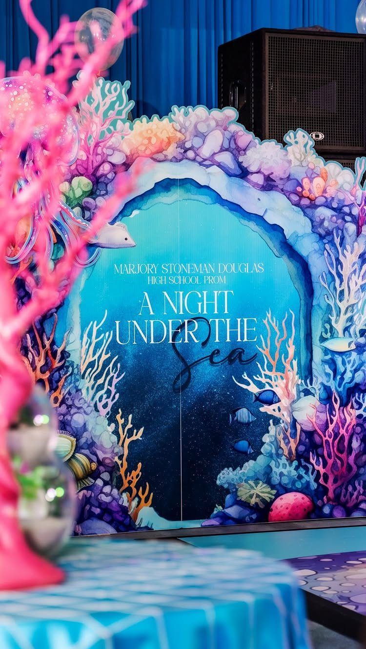 Underwater themed prom backdrop with colorful coral and A Night Under the Sea text.
