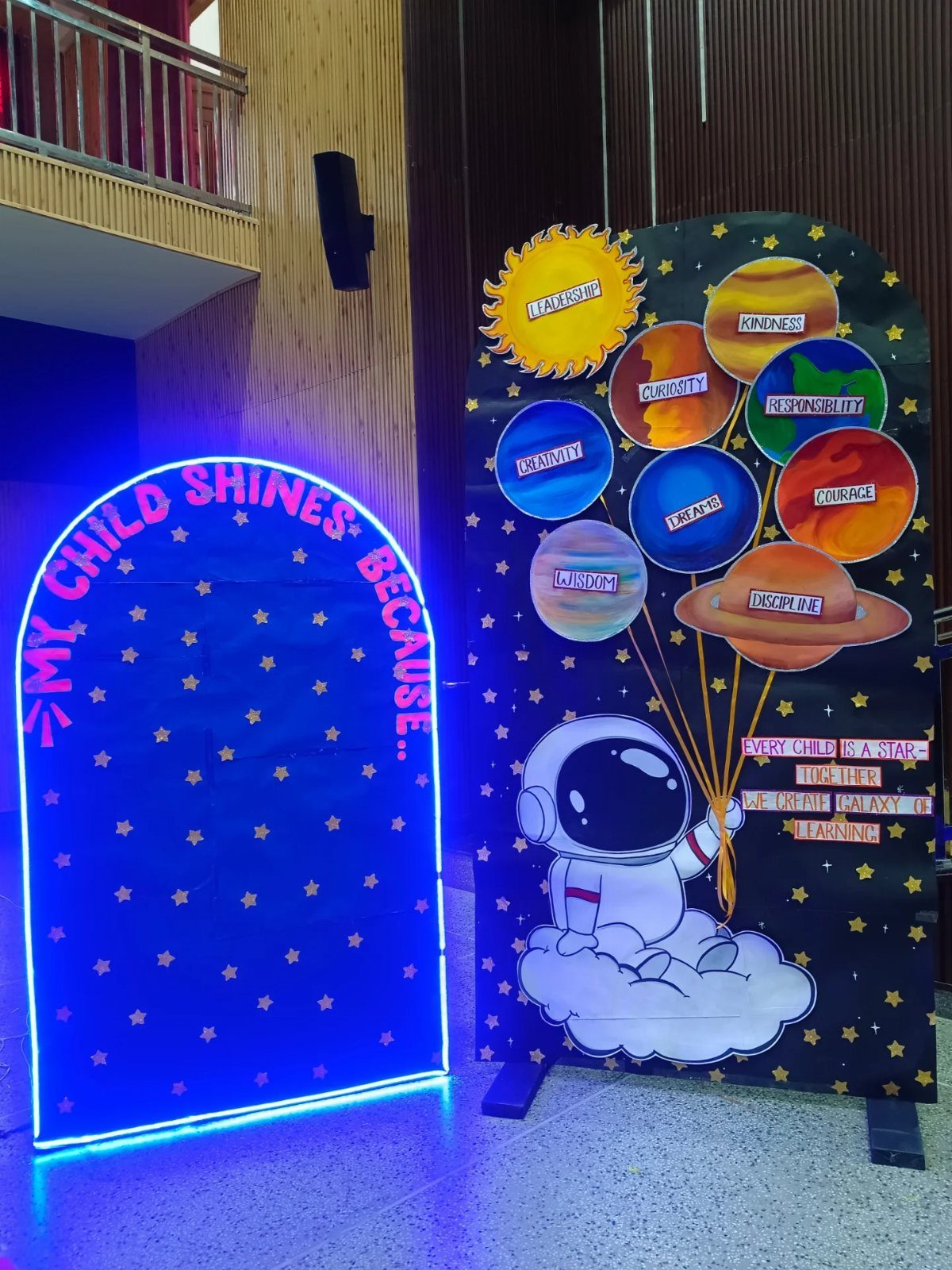 Space-themed graduation backdrops with a neon blue arch and astronaut illustration.