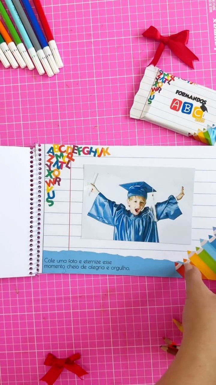 Open memory book with a child's graduation photo and colorful alphabet letters.