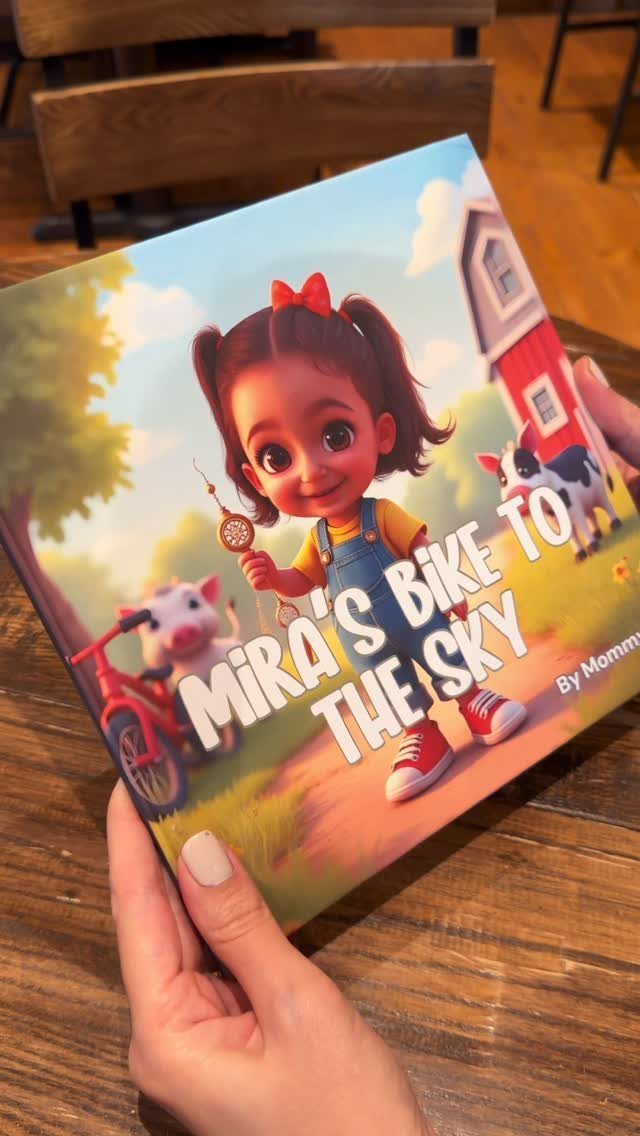 Children's book titled Mira's Bike to the Sky held by two hands.