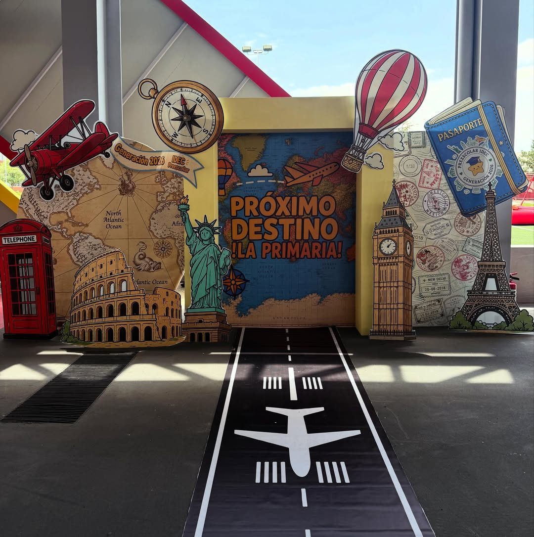 Travel-themed graduation backdrop with world landmarks, a red airplane, and a runway floor.