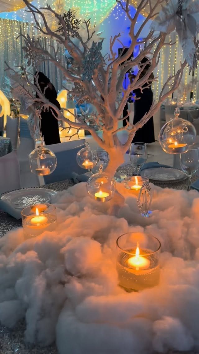 White decorative tree with faux snow and glowing candles in a banquet setting