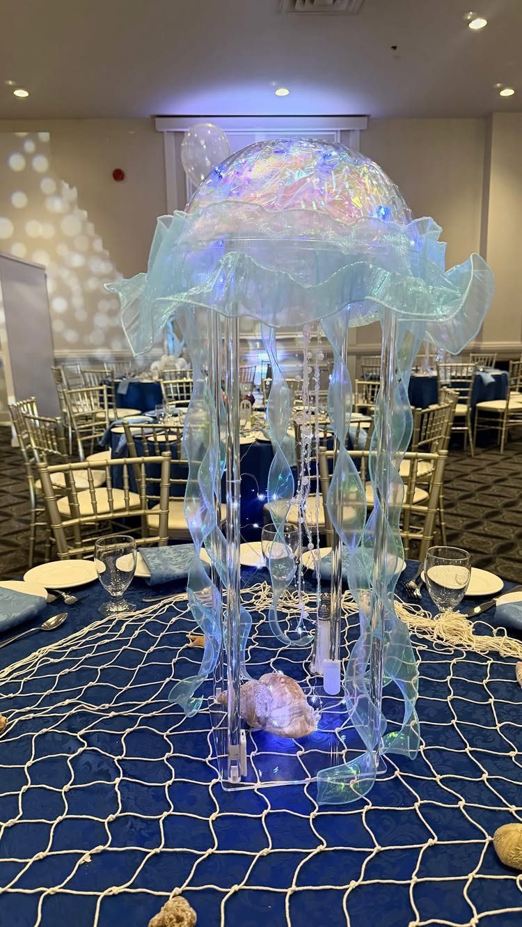 Jellyfish shaped centerpiece on a blue table with a decorative fishing net