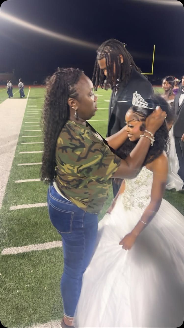 Woman placing a silver tiara on a girl in a white prom dress