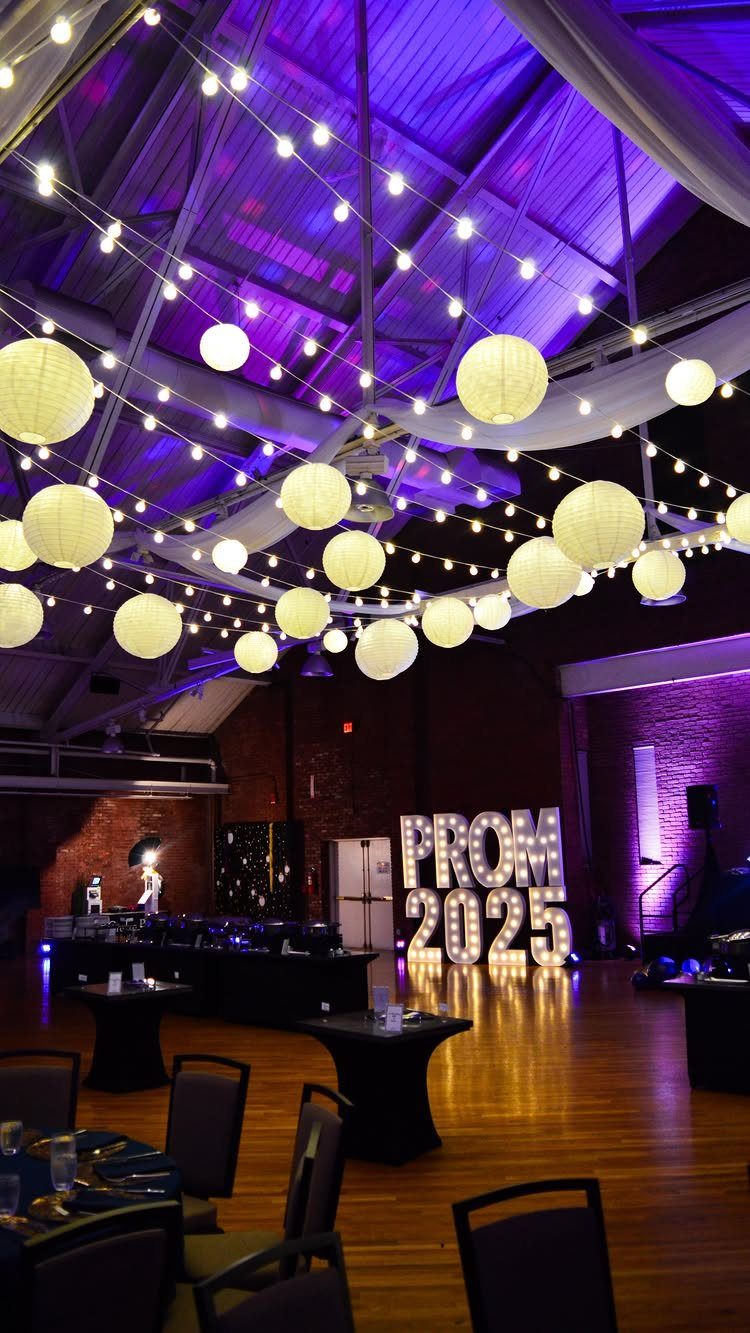 Prom party decorations featuring white lanterns, string lights, and glowing PROM 2025 letters.