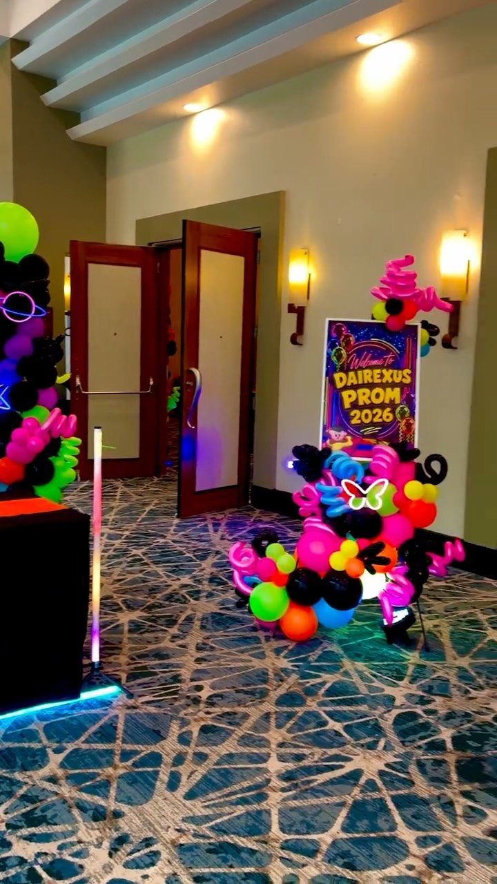 Neon balloon sculptures and a prom 2026 sign in a hotel hallway.