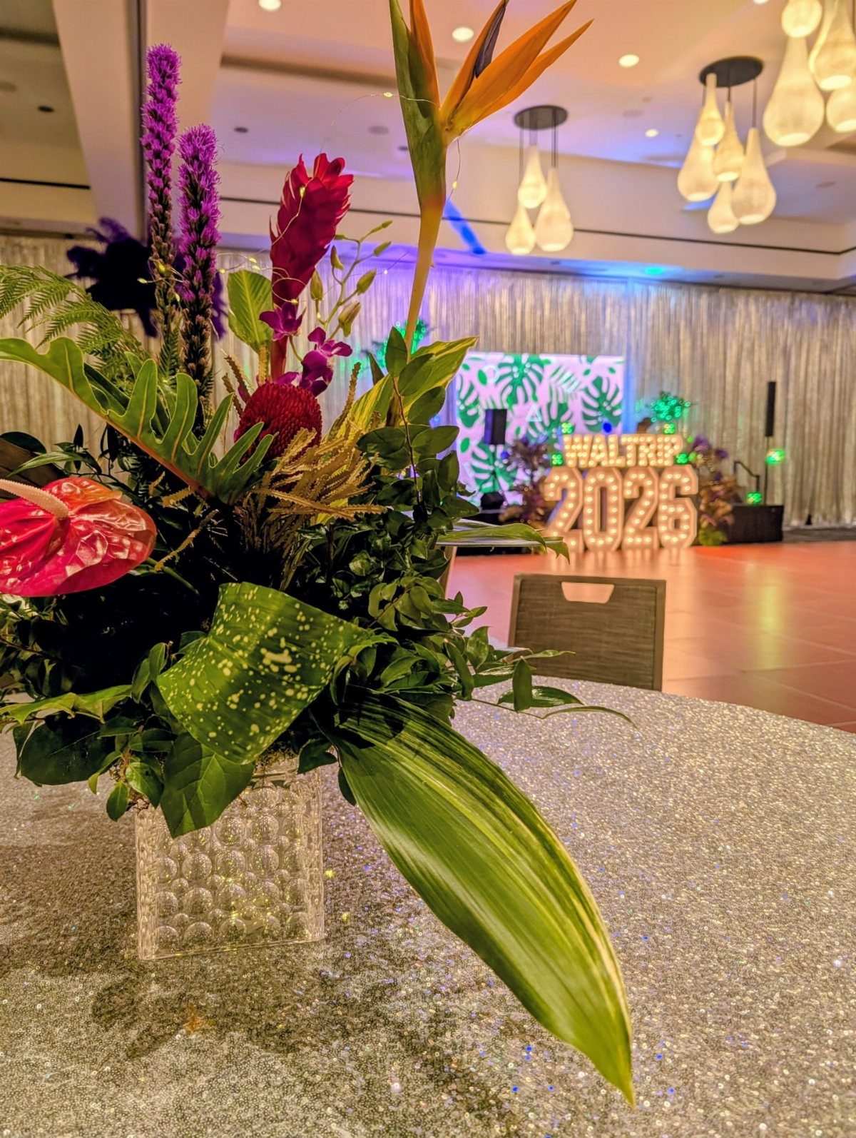 Tropical floral arrangement with bird of paradise on a silver glitter tablecloth