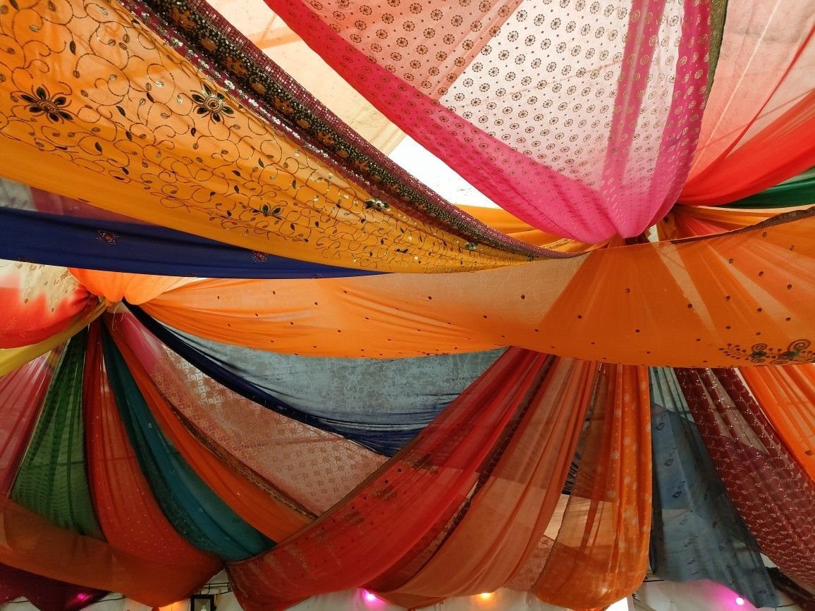 Multi-colored sheer fabric drapes radiating from a center point across a ceiling.