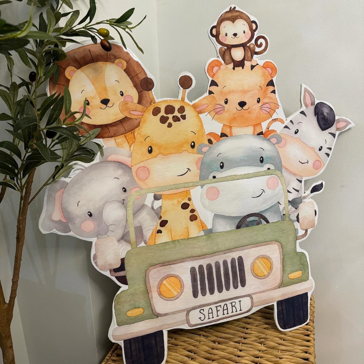 Cartoon safari animals in a green jeep cardboard cutout next to a plant