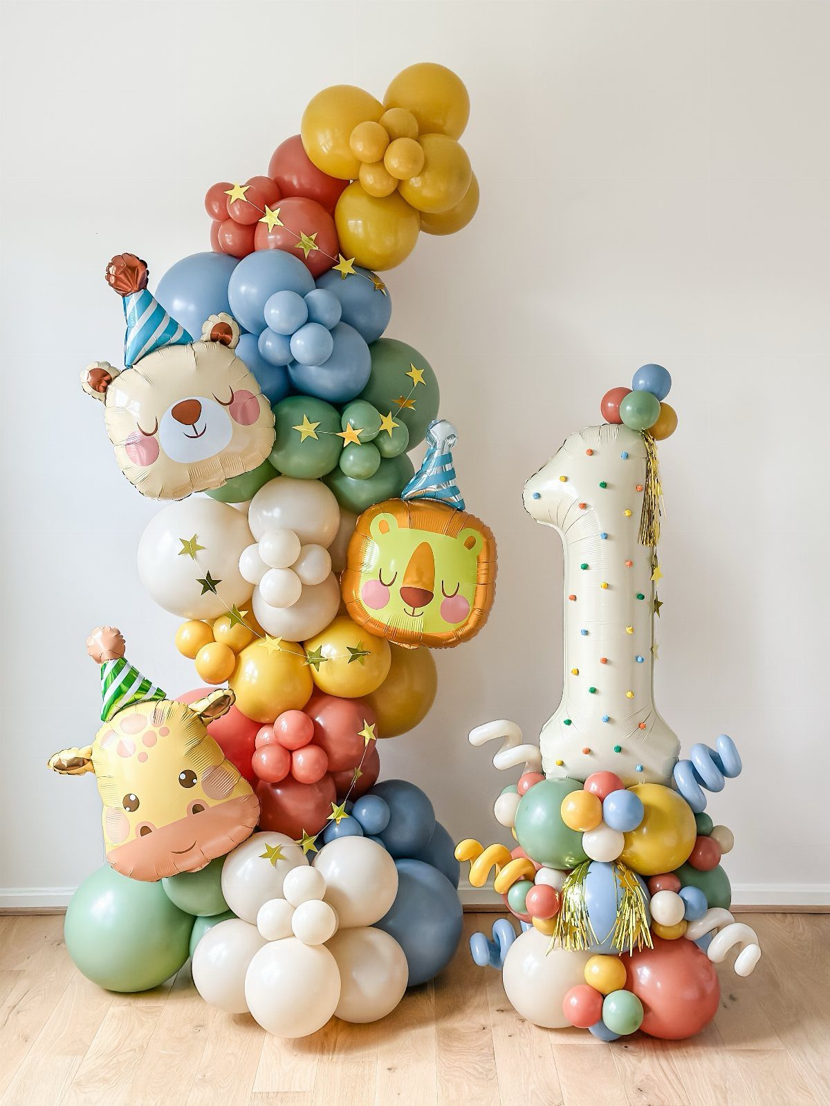 Balloon garland with animal foil balloons and a large number one for a party.
