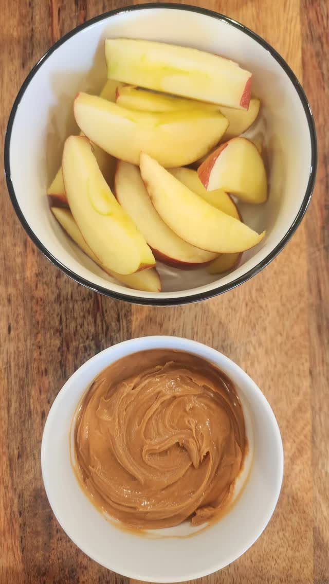 Sliced apples in a bowl with a side of creamy peanut butter dip.