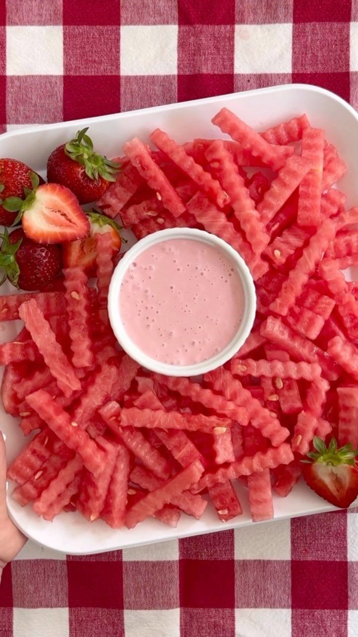 Crinkle-cut watermelon and strawberries on a platter with a bowl of pink yogurt dip.