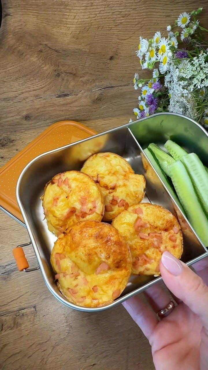 Mini egg muffins and celery sticks in a metal bento lunch box.