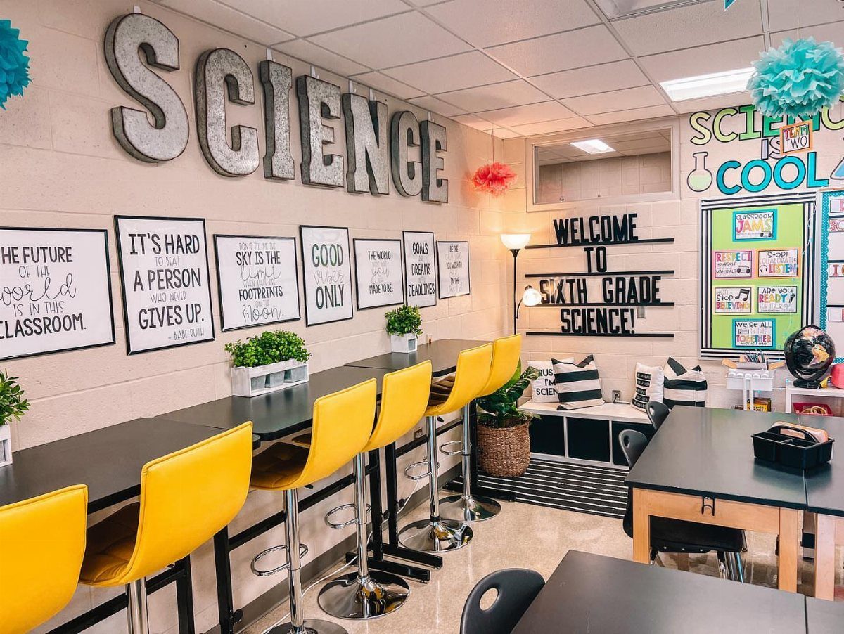 Science classroom with large silver wall letters, yellow stools, and educational decorations.