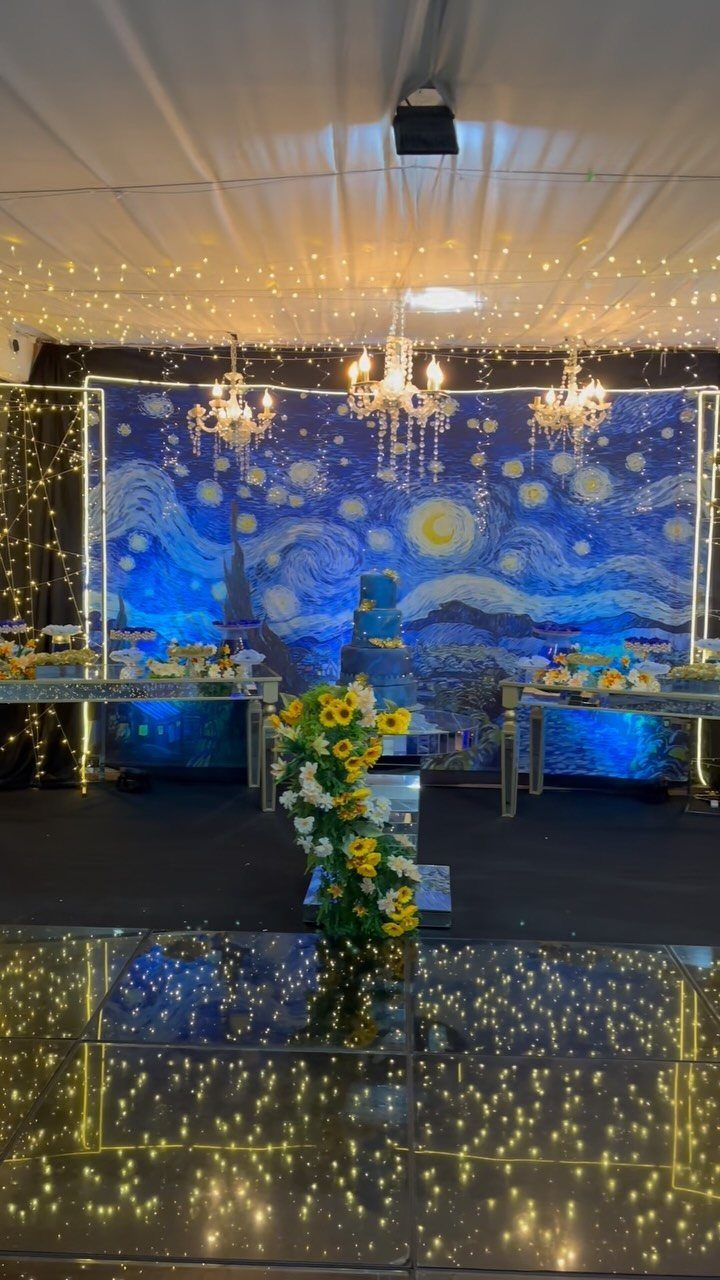 Starry Night themed prom venue with blue backdrop, chandeliers, and yellow sunflowers.