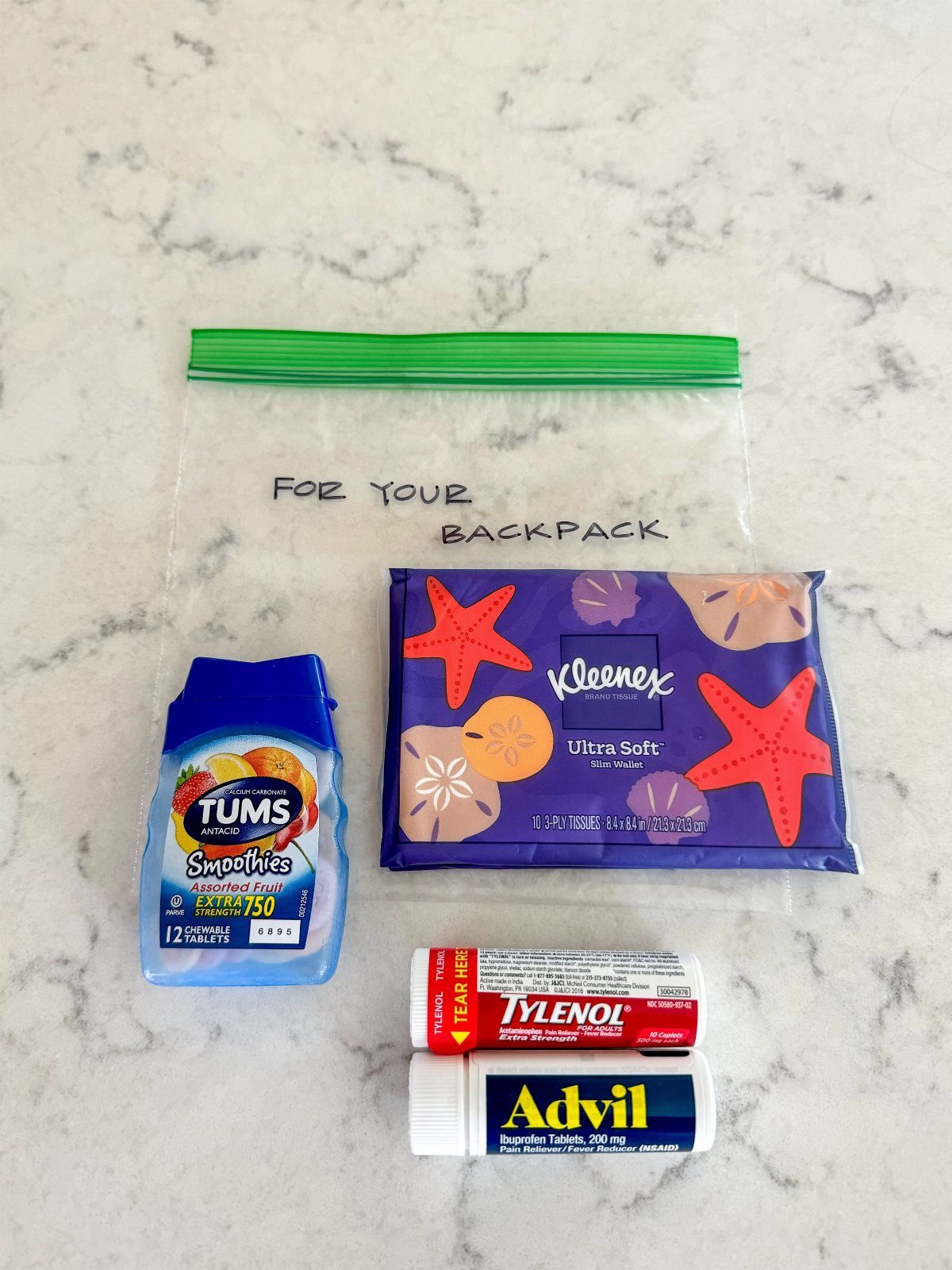 Survival kit with Tums, Tylenol, Advil, and tissues in a plastic bag.