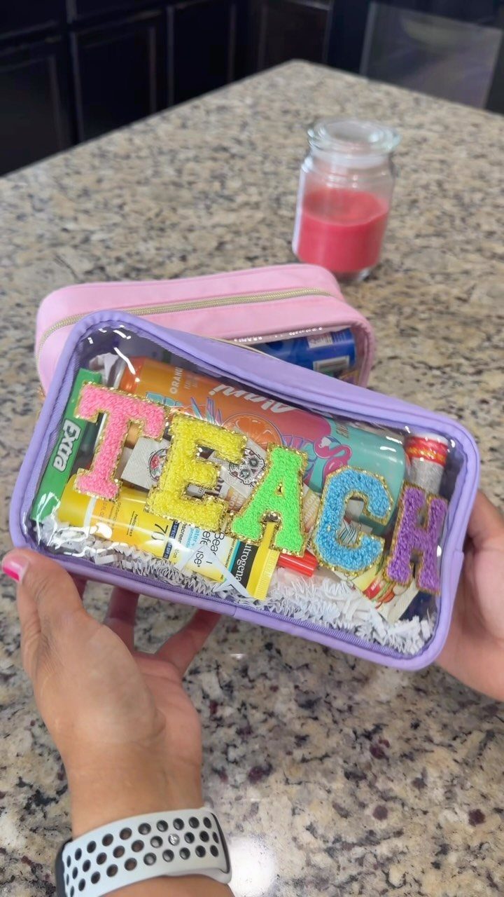 Purple clear pouch filled with teacher survival kit items and glittery TEACH letters.