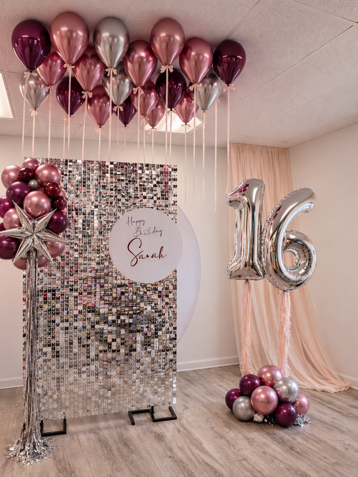 Silver shimmer wall backdrop with pink and purple balloons and silver 16 balloons.