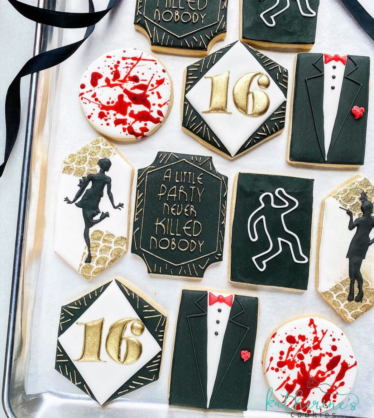 Themed sugar cookies with tuxedos, blood splatters, and gold text for a party.
