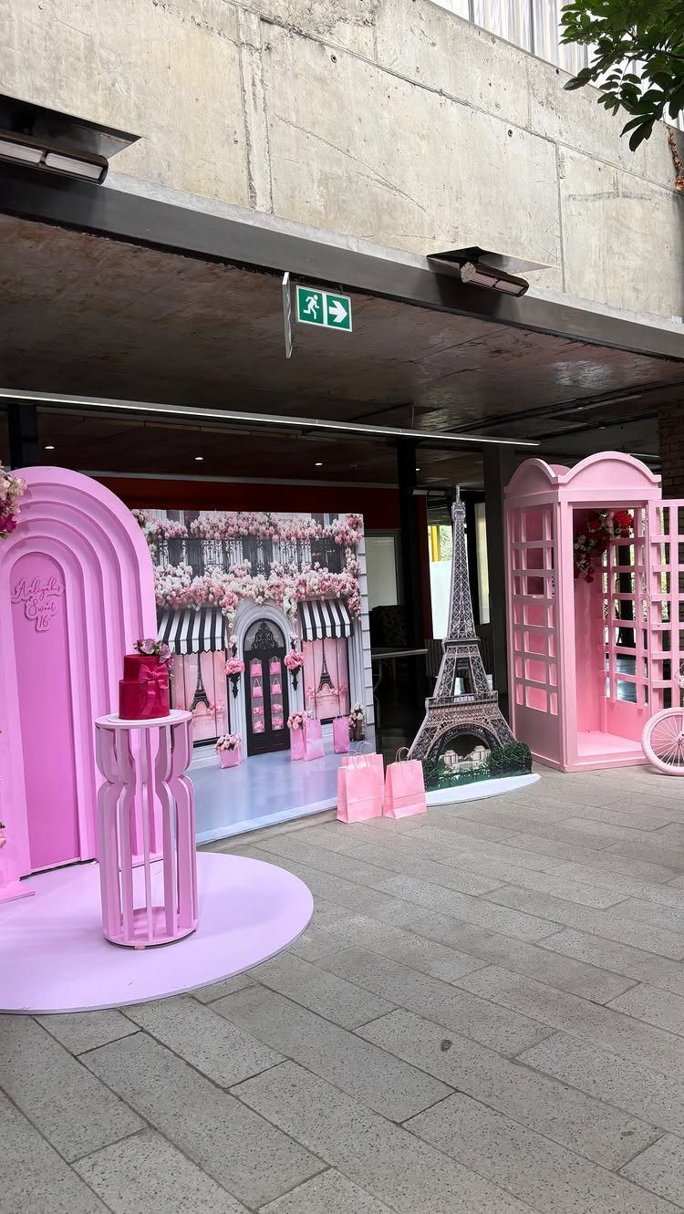 Pink Parisian themed event setup with Eiffel Tower model and street backdrop.