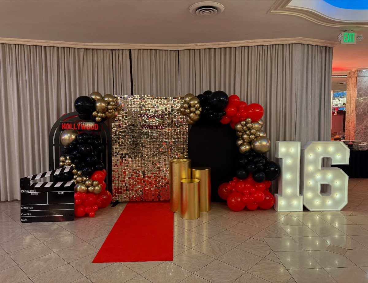 Red carpet entrance with gold sequin backdrop, balloons, and large glowing number 16.