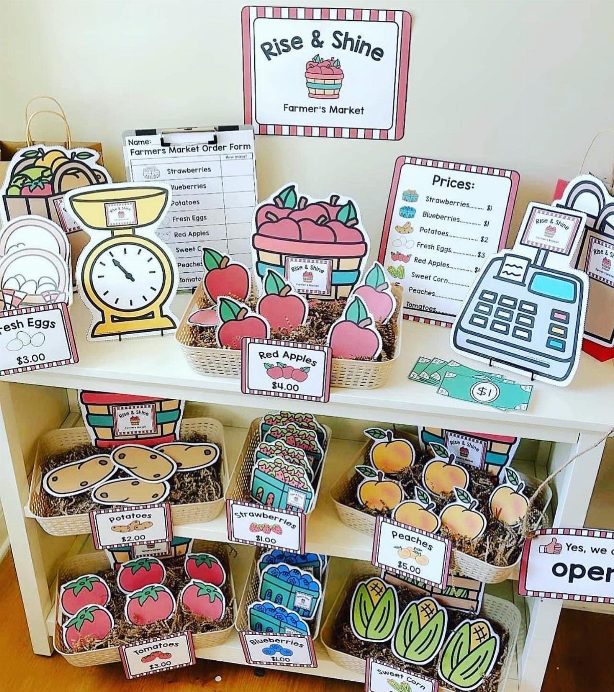 Farmers market themed display with cartoon produce cutouts and price tags on shelves.