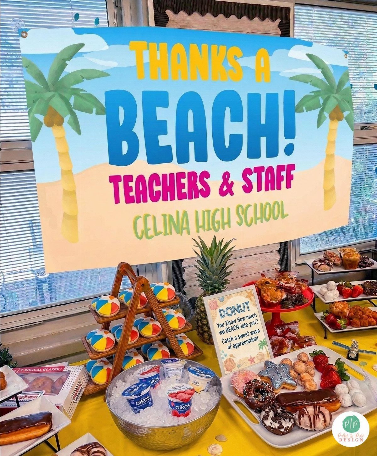 Beach-themed appreciation station with a large sign, beach balls, and assorted treats.