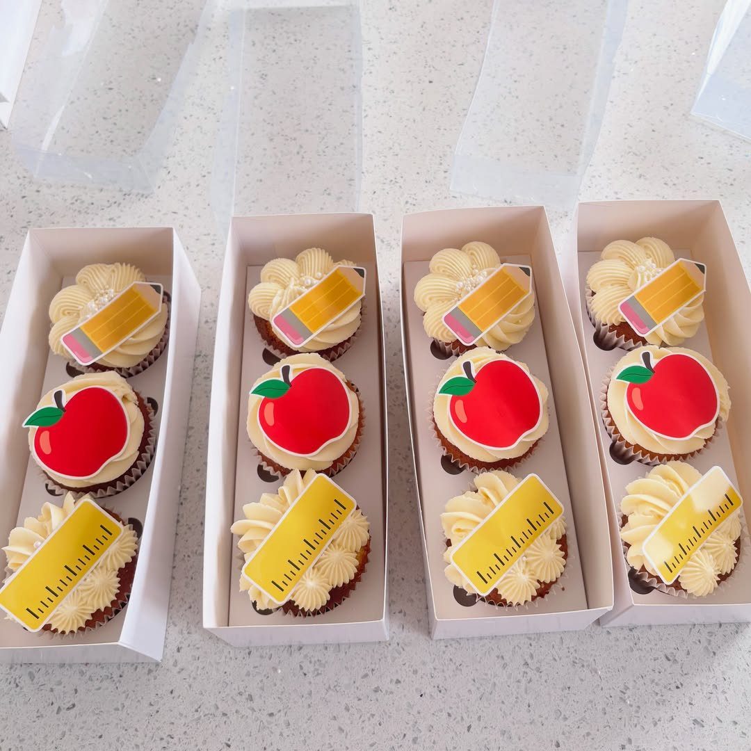 Cupcakes with apple, ruler, and pencil toppers in white gift boxes.