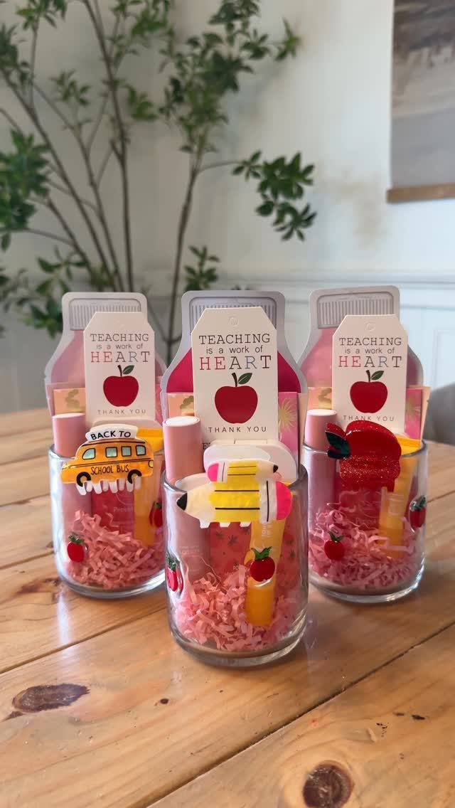 Three glass jars filled with pink paper, pens, and teacher appreciation cards.
