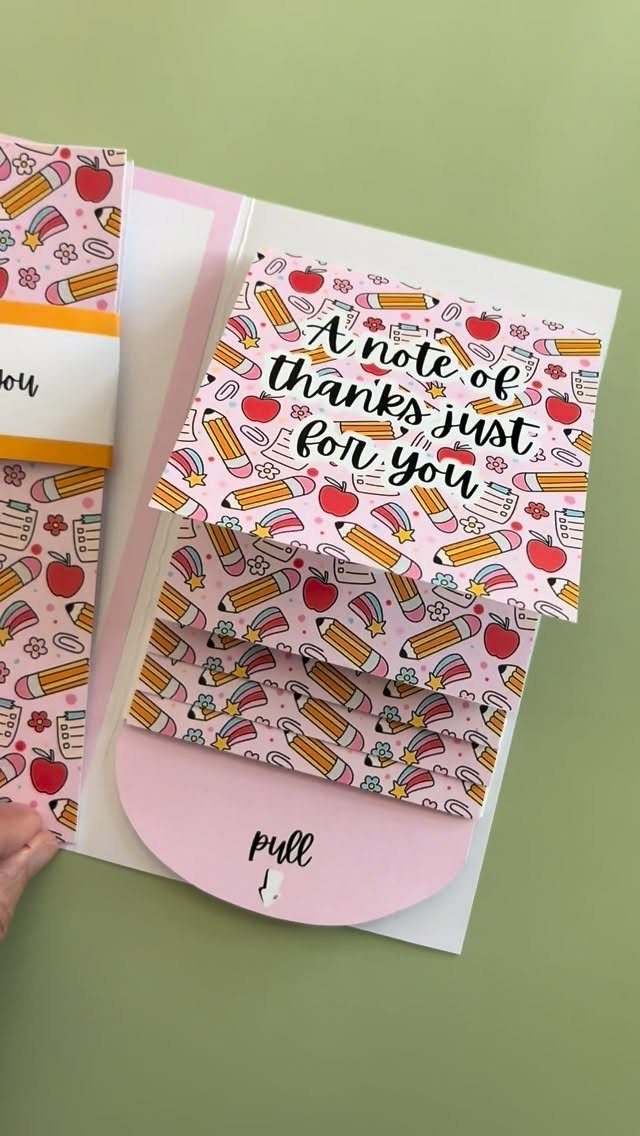 Handmade pink thank you card with pencil and apple patterns and a pull tab.