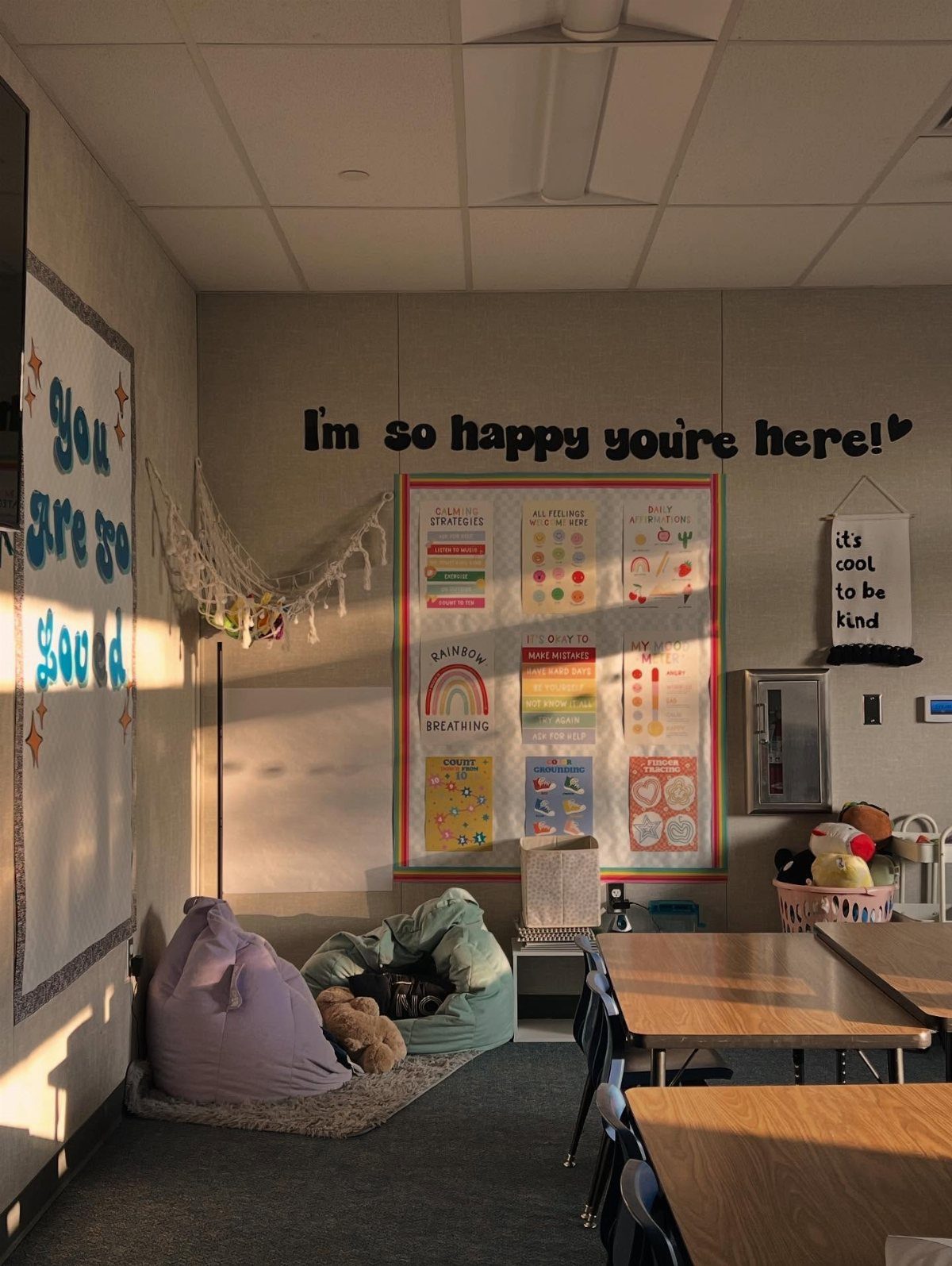 Classroom calm down corner with beanbags, a rug, and positive wall messages.