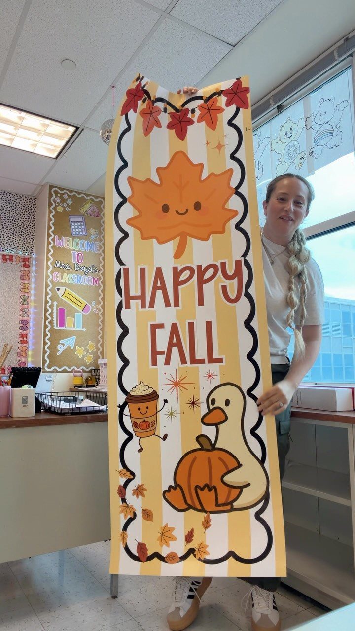 Woman holding a vertical yellow striped fall banner with autumn illustrations and text.