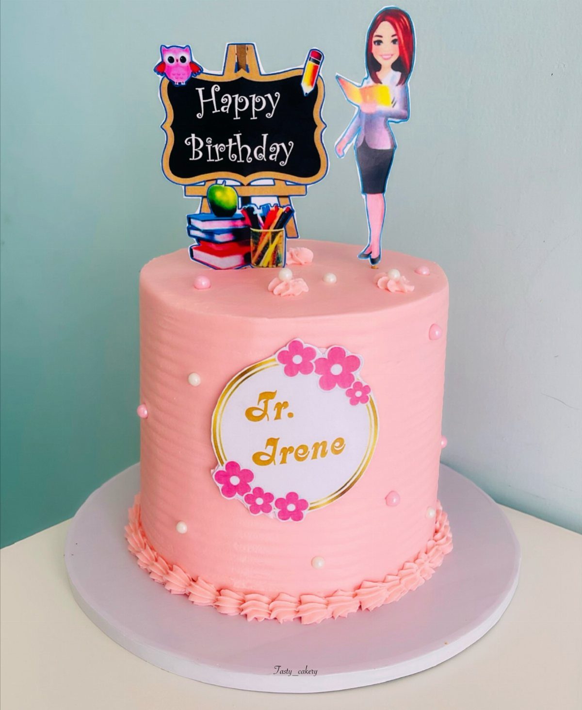 Pink birthday cake for a teacher with chalkboard and teacher cartoon toppers.